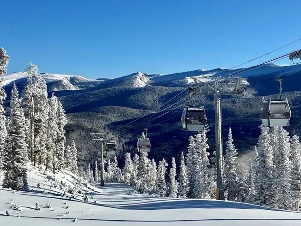 A picturesque exterior view of snow-covered slopes, ski lift gondolas, and distant mountains framed by pine trees. The scene is both adventurous and serene, inviting guests to imagine seasonal outdoor activity just steps away.